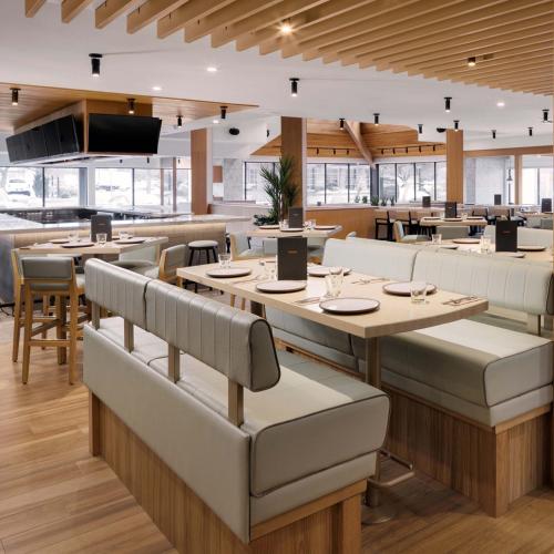 a restaurant with tables and couches and a cafeteria at Sandman Hotel & Suites Kelowna in Kelowna