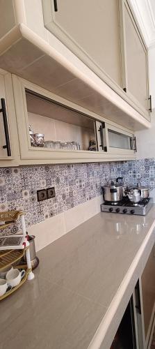a kitchen with white cabinets and a counter top at superbe appartement famille in Oualidia