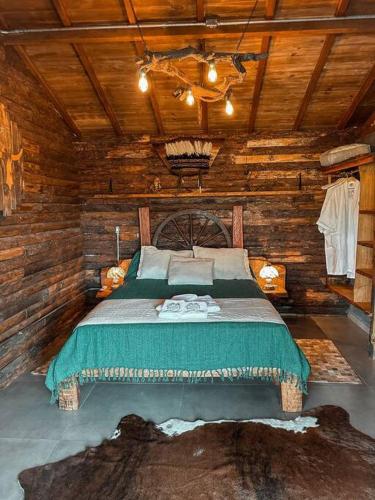 a bedroom with a bed in a wooden cabin at Cabanas do Paiol Texas Cabin Toledo MG in Toledo