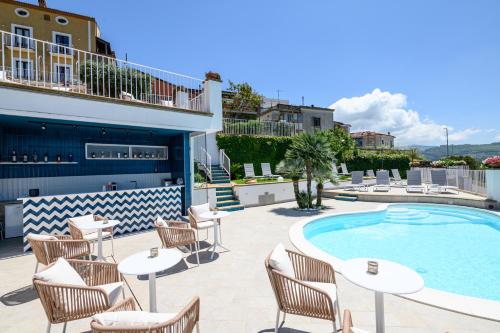 a patio with tables and chairs next to a swimming pool at Palazzo Gargano in Prignano Cilento