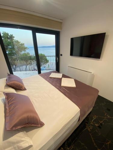 a bedroom with a large bed with a large window at Leandra in Baška Voda