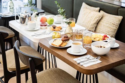a table with breakfast food on it in a restaurant at Best Western Premier The Blake Paris Gare Saint Lazare in Paris