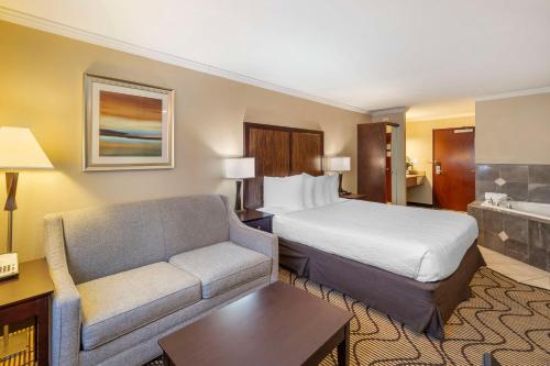 a hotel room with a bed and a couch at Best Western Plus Orchid Hotel & Suites in Roseville