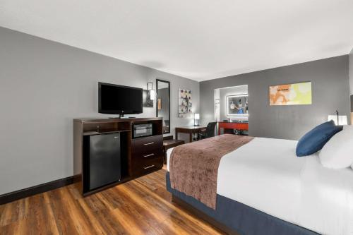 a hotel room with a bed and a flat screen tv at Best Western Corbin Inn in Corbin