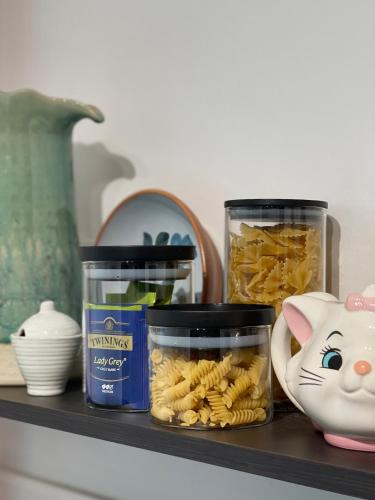 a shelf with two jars of pasta and a cat toy at Splendide Studio très proche gare - 16min Champs-Élysées in Sartrouville