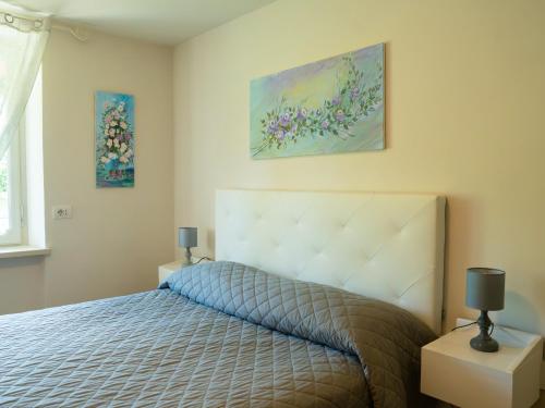 a bedroom with a bed and two paintings on the wall at Casa Fornace 28 in La Morra