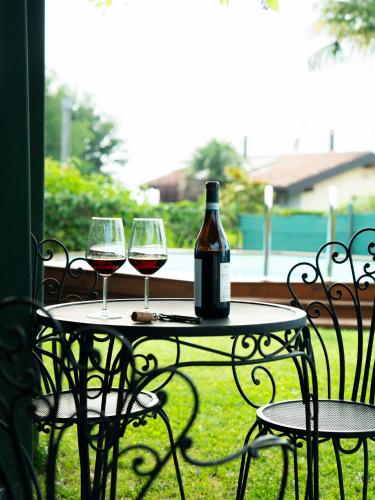 a table with two glasses of red wine on it at Casa Fornace 28 in La Morra