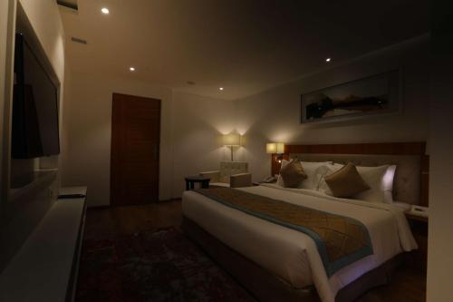 a hotel room with a large bed and a television at Best Western Plus Tejvivaan in Visakhapatnam