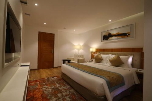 a hotel room with a large bed and a television at Best Western Plus Tejvivaan in Visakhapatnam