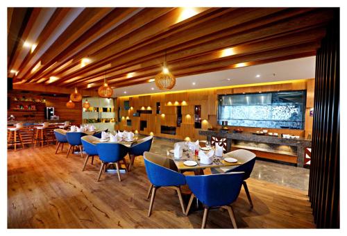 a restaurant with blue chairs and tables and a bar at Best Western Plus Tejvivaan in Visakhapatnam