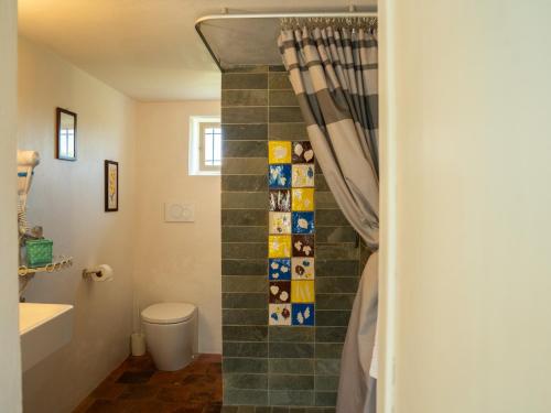 a bathroom with a toilet and a shower curtain at Casa Fornace 28 in La Morra