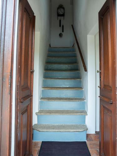 a staircase with blue steps and a clock on the wall at Casa Fornace 28 in La Morra