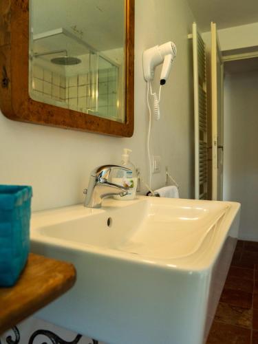 a bathroom sink with a hair dryer and a mirror at Casa Fornace 28 in La Morra