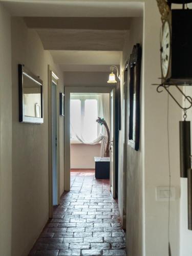 a hallway with a clock on the wall and a window at Casa Fornace 28 in La Morra