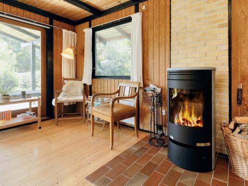 a living room with a fireplace and a table and chairs at Charming Retreat on Eno - By Traum Ferienwohnungen in Karrebæksminde