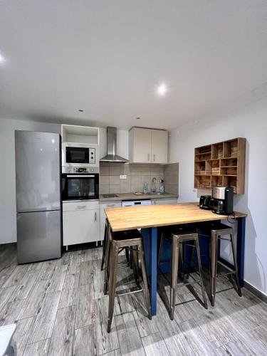une cuisine avec une table en bois et un réfrigérateur dans l'établissement Luxury Stay with Terrace and AC 10 min to Paris, à Vitry-sur-Seine