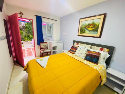 a bedroom with a yellow bed and a red door at House Marfito Airport in Cartagena de Indias