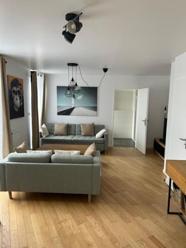 - un salon avec deux canapés et un ventilateur de plafond dans l'établissement Duplex lumineux à 5min de Paris - Vue sur Sacré Coeur, à Clichy