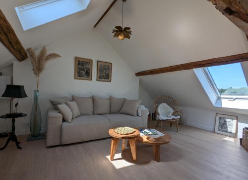 a living room with a couch and a table at Chantilly sous les toits in Chantilly
