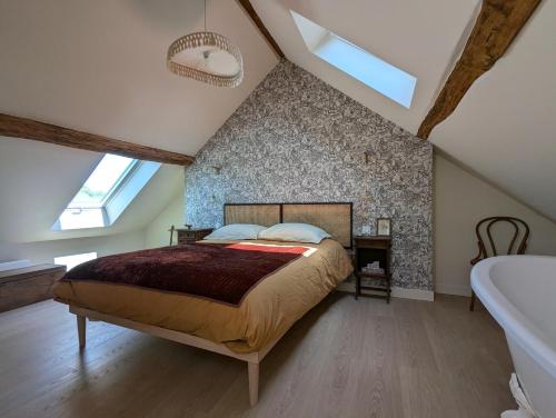 a bedroom with a large bed and a bathroom at Chantilly sous les toits in Chantilly