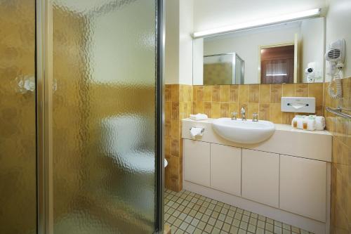 a bathroom with a shower, sink, and toilet at Windsor Lodge in Perth