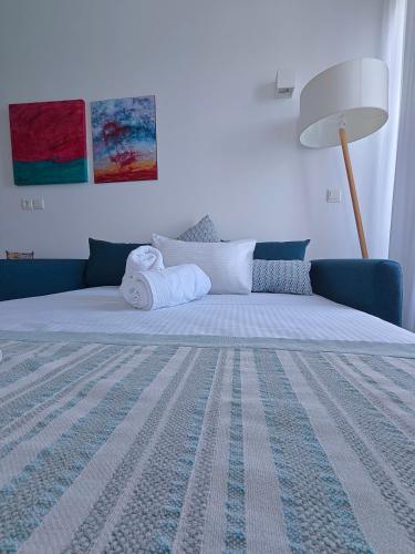 a bedroom with a large bed with a blue couch at Aurora - Rooms & Suites - Spetses in Spetses