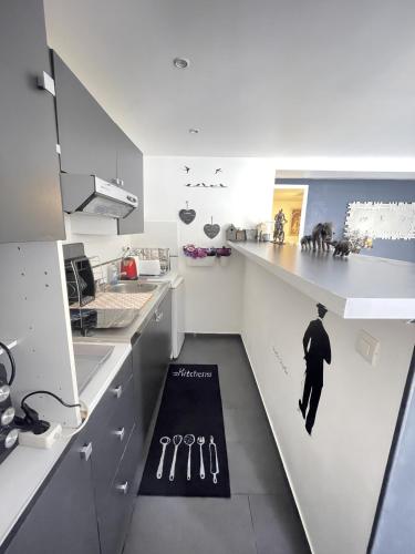 une cuisine avec un homme en costume sur le comptoir dans l'établissement Beau 2 pièces à gare de Bondy et à seulement 10 min de Paris, à Bondy