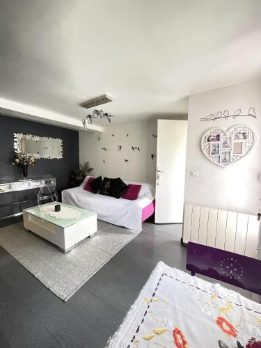 un salon avec un lit et une table dans l'établissement Beau 2 pièces à gare de Bondy et à seulement 10 min de Paris, à Bondy