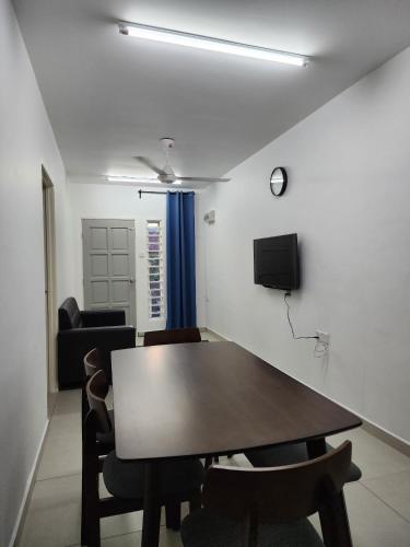 a dining room with a wooden table and chairs at Homestay Warisan Iman in Klang