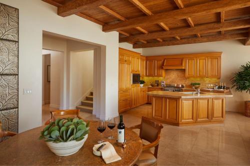 a kitchen with wooden cabinets and a table with wine bottles at The Resort at Pelican Hill in Crystal Cove