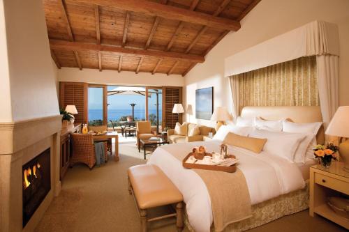 a bedroom with a large bed and a fireplace at The Resort at Pelican Hill in Crystal Cove
