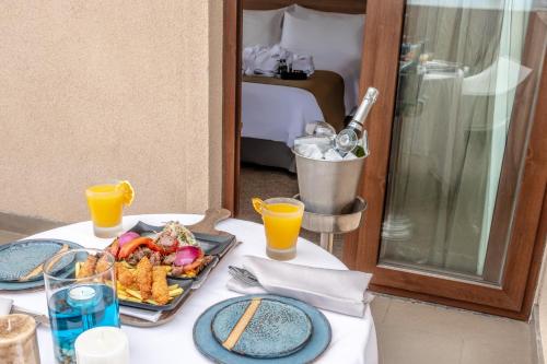 a table with a plate of food and two glasses of orange juice at Geotel Antofagasta in Antofagasta
