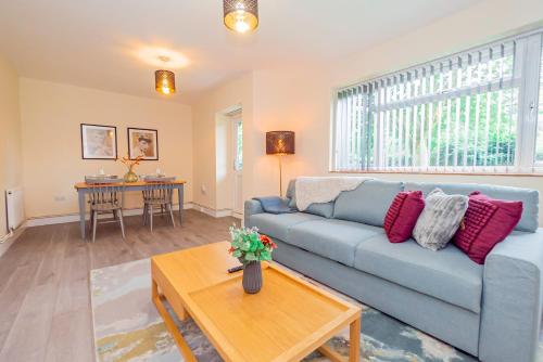 a living room with a blue couch and a table at Stylish 2-Bed Flat on Banbury Road in Oxford