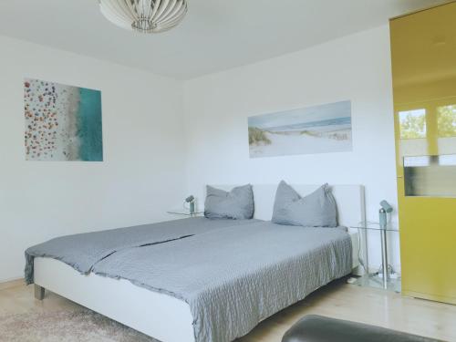 a white bedroom with a bed in a room at Ferienwohnung Forest & Wein in Neustadt an der Weinstraße