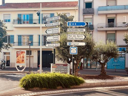 un panneau de rue avec de nombreux panneaux devant un bâtiment dans l'établissement Appartement Cosy Centre-ville, à Saint-Raphaël
