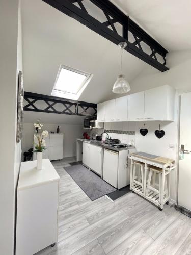 d'une cuisine avec des placards blancs et une lucarne. dans l'établissement Beau studio lumineux à Bondy gare à seulement 10 min de Paris, à Bondy