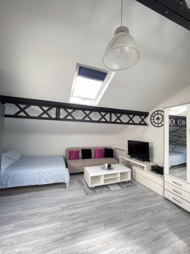 - une chambre avec 2 lits, une télévision et une table dans l'établissement Beau studio lumineux à Bondy gare à seulement 10 min de Paris, à Bondy