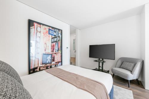 a bedroom with a bed and a chair and a television at Marques Design Apartments in Porto