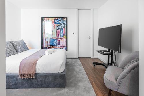 a bedroom with a bed and a tv and a chair at Marques Design Apartments in Porto