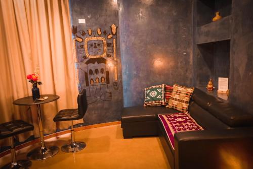 a living room with a leather couch and a table at Chakana Hotel Boutique Centro in Quito