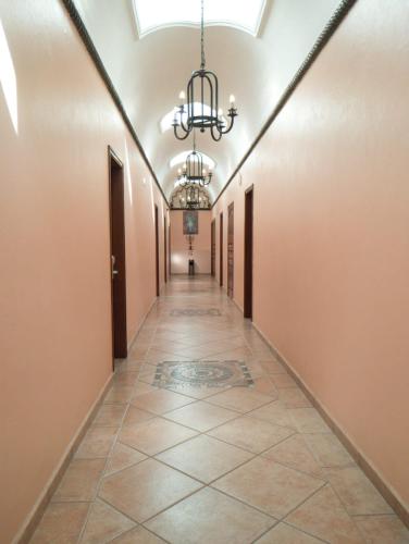 a hallway with a chandelier and a tile floor at Hotel Vista Hermosa in Cuernavaca
