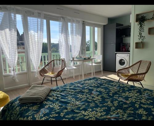 - une chambre avec un grand lit, des chaises et une table dans l'établissement FABULEUX STUDIO à coté du CHATEAU, à Bagnoles-de-l'Orne