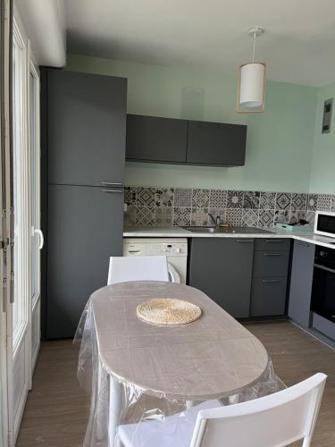 Il comprend une cuisine équipée d'une table et de chaises. dans l'établissement FABULEUX STUDIO à coté du CHATEAU, à Bagnoles-de-l'Orne