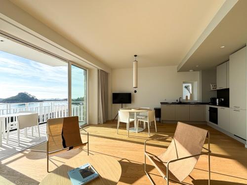 un salon avec une table et des chaises et une cuisine dans l'établissement LES MELOINES T3, Luxurious 2 Bedroom Seaside, à Trébeurden