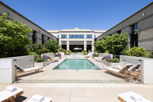 a swimming pool with lounge chairs and a building at Holiday Inn Express - Temuco by IHG in Temuco