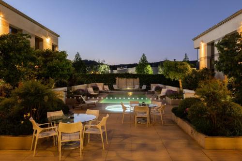 a patio with tables and chairs next to a pool at Holiday Inn Express - Temuco by IHG in Temuco