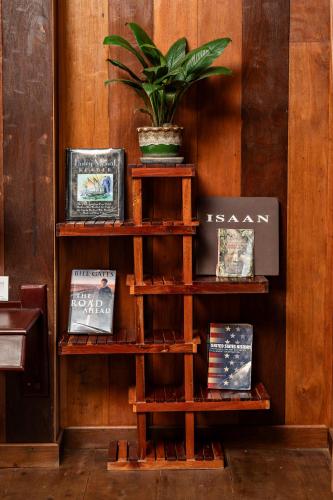 a book shelf with books and a potted plant on it at Tiny Home in Phumi Ta Phul