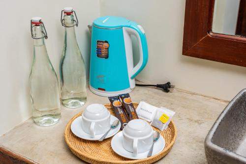 a kitchen counter with a juicer and two glass bottles at Tiny Home in Phumi Ta Phul