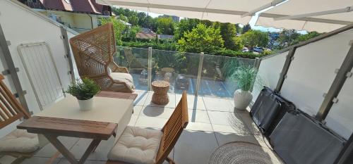 a balcony with a table and chairs on a patio at Infinity Apartman Lellemarine in Balatonlelle