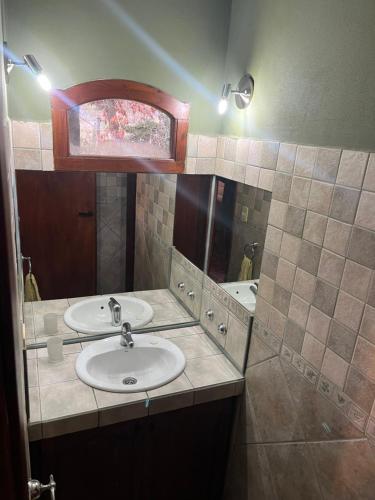 a bathroom with two sinks and a mirror at La Margarita in El Bolsón